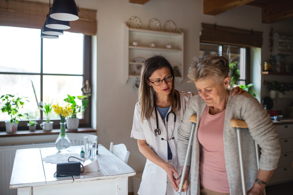 Home health caregiver visiting a senior woman indoors during a care visit