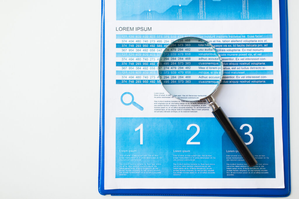 Clipboard with a printed performance report and a magnifying glass over the figures